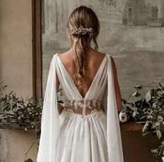 the back of a woman's wedding dress, with long sleeves and an open shoulder