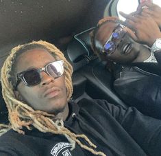 two men with dreadlocks sitting in a car