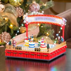 a christmas display on a table in front of a christmas tree