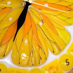 a close up of a clock with a butterfly on it's face and numbers