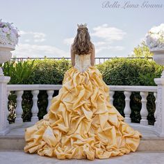 a woman in a yellow dress is sitting on a balcony with her back to the camera