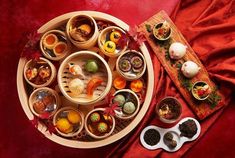 an assortment of food is arranged on a tray with spoons and bowls next to it