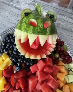 a watermelon frog head made out of fruits and vegetables on a platter