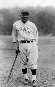 an old black and white photo of a baseball player with a bat in his hand