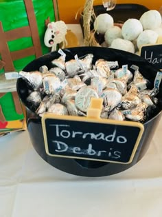 a bowl filled with lots of candy sitting on top of a table next to other items