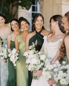 a group of women standing next to each other holding bouquets