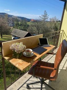 a laptop computer sitting on top of a wooden desk next to a cup of coffee