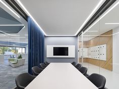 an empty conference room with chairs and a television mounted on the wall in front of it