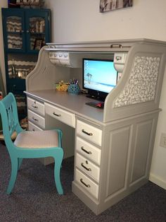 a desk with a chair and a computer on it in a room that has carpeted flooring