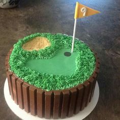 a cake that looks like a golf course with a flag sticking out of the hole