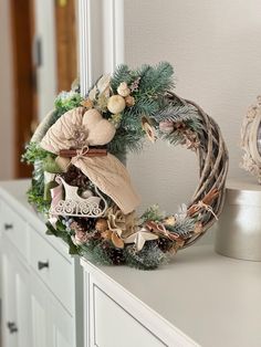 a christmas wreath sitting on top of a white dresser