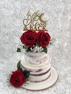 a wedding cake with red roses on top