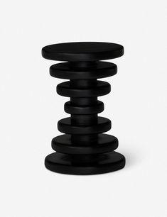 a stack of black plates sitting on top of each other in front of a white background