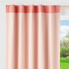 an open window with pink curtains and green grass