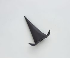 a black origami hat sitting on top of a white table