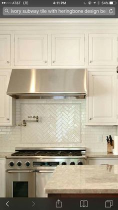 a stove top oven sitting inside of a kitchen next to white cabinets and counter tops