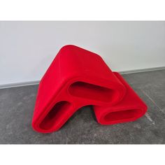 a red piece of furniture sitting on the floor