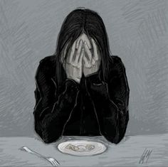 a woman sitting at a table with her hands covering her face