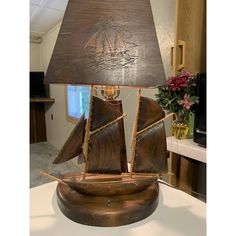 a lamp that is sitting on top of a table with a sailboat on it