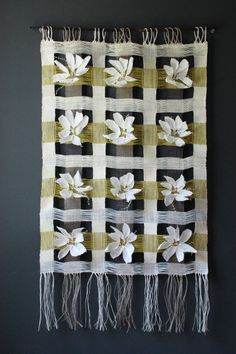 a wall hanging with white flowers on it