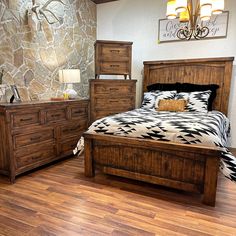 a bed room with a neatly made bed and wooden furniture on the hardwood flooring