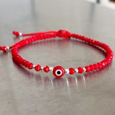 Adjustable red Evil eye bracelet crafted by hand from 100% red nylon string. Description: *3mm red crystal *3, 2 and 1mm silver beads *Red glass evil eye Size: Adjustable from 6" to 8" The bracelet opens by pulling the beads closest to the sliding knot in opposite directions and closes by pulling the small, dangling blue beads in opposite directions. Red Evil Eye Bracelet For Good Luck, Adjustable Red Evil Eye Bracelet Hand-strung, Adjustable Red Evil Eye Bracelet, Hand-strung, Red Spiritual Friendship Bracelets With Evil Eye, Red Spiritual Friendship Bracelet With Evil Eye, Adjustable Red Evil Eye Friendship Bracelets, Red Evil Eye Friendship Bracelet, Adjustable Red Evil Eye Bracelet, Red Evil Eye Round Bead Jewelry