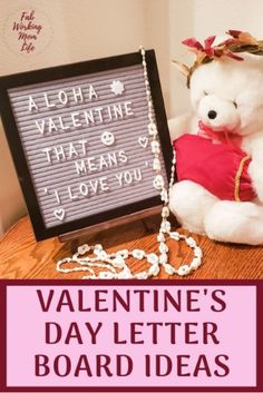 a white teddy bear sitting next to a valentine's day letter board