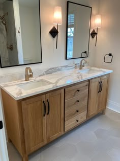 a bathroom with two sinks and mirrors on the wall