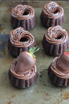 chocolate desserts with strawberries in the middle on a baking sheet, ready to be eaten