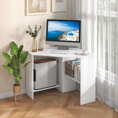 a white computer desk with a monitor and keyboard on it next to a potted plant