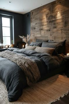 a large bed sitting next to a window in a room with black walls and wooden headboard