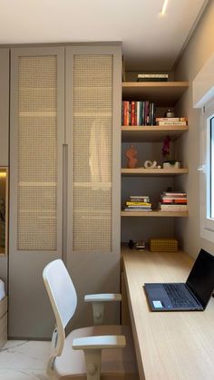 a laptop computer sitting on top of a wooden desk next to a book shelf filled with books