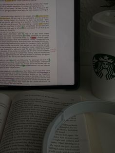 an open book next to a cup of coffee