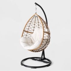 a hanging chair with a white cushion and black stand