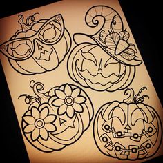 three pumpkins with faces drawn on them sitting next to each other in front of a sheet of paper