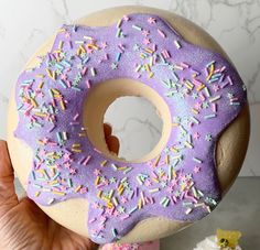 someone holding up a doughnut with sprinkles on it