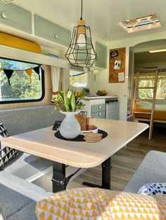 the interior of a camper with a dining table and couches in front of it