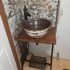 an old fashioned sink sits on top of a wooden table in the corner of a bathroom