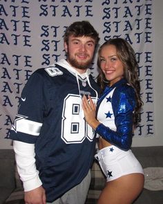 a man and woman dressed up in cheerleader gear posing for a photo with the wall behind them