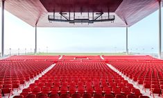 an empty stadium filled with red chairs