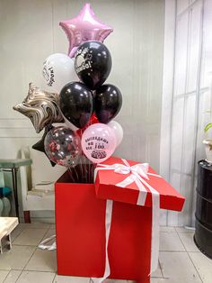 a red gift box with balloons in it