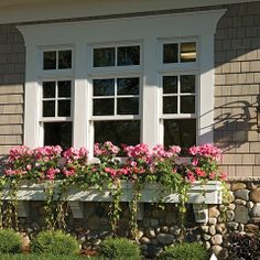 a house with flowers in the window boxes