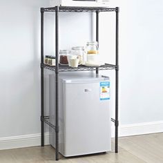 a white refrigerator freezer sitting on top of a metal shelf next to a wall