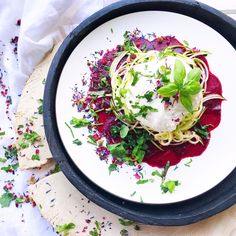 a white plate topped with food on top of a wooden table next to a napkin