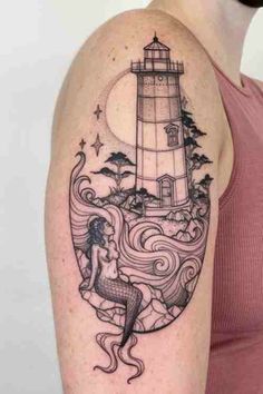 a woman's arm with a lighthouse and mermaid tattoo on the left side of her body