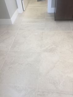 a kitchen floor with white tile and brown cabinets