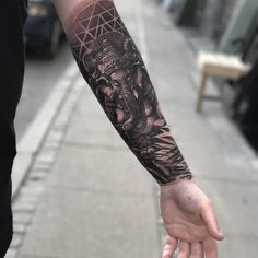 an elephant tattoo on the arm of a person holding their hand out in front of them