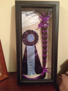 a framed photo with two ribbons and a purple ribbon