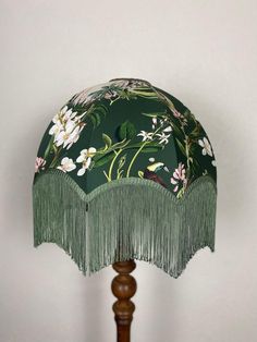 a green lamp with fringes and flowers on it