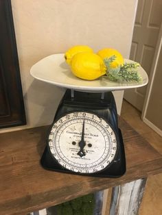 two lemons are sitting on top of a weight scale, and one is yellow